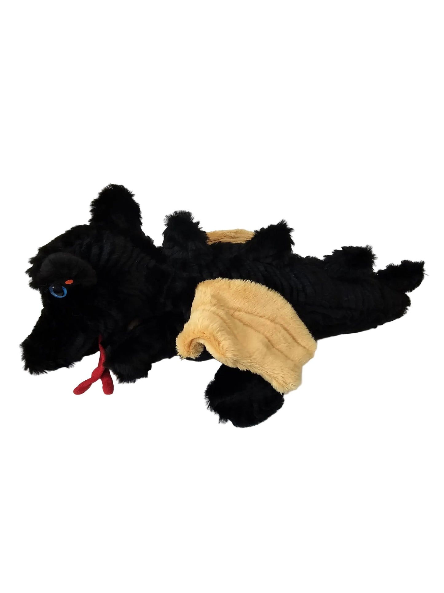 Adragon plush costume or stuffed animal lying on a white floor against a white paneled wall. The costume has fluffy black fur, a tan fuzzy belly patch, a red ribbon hanging from the nose area, and blue eyes on the face.