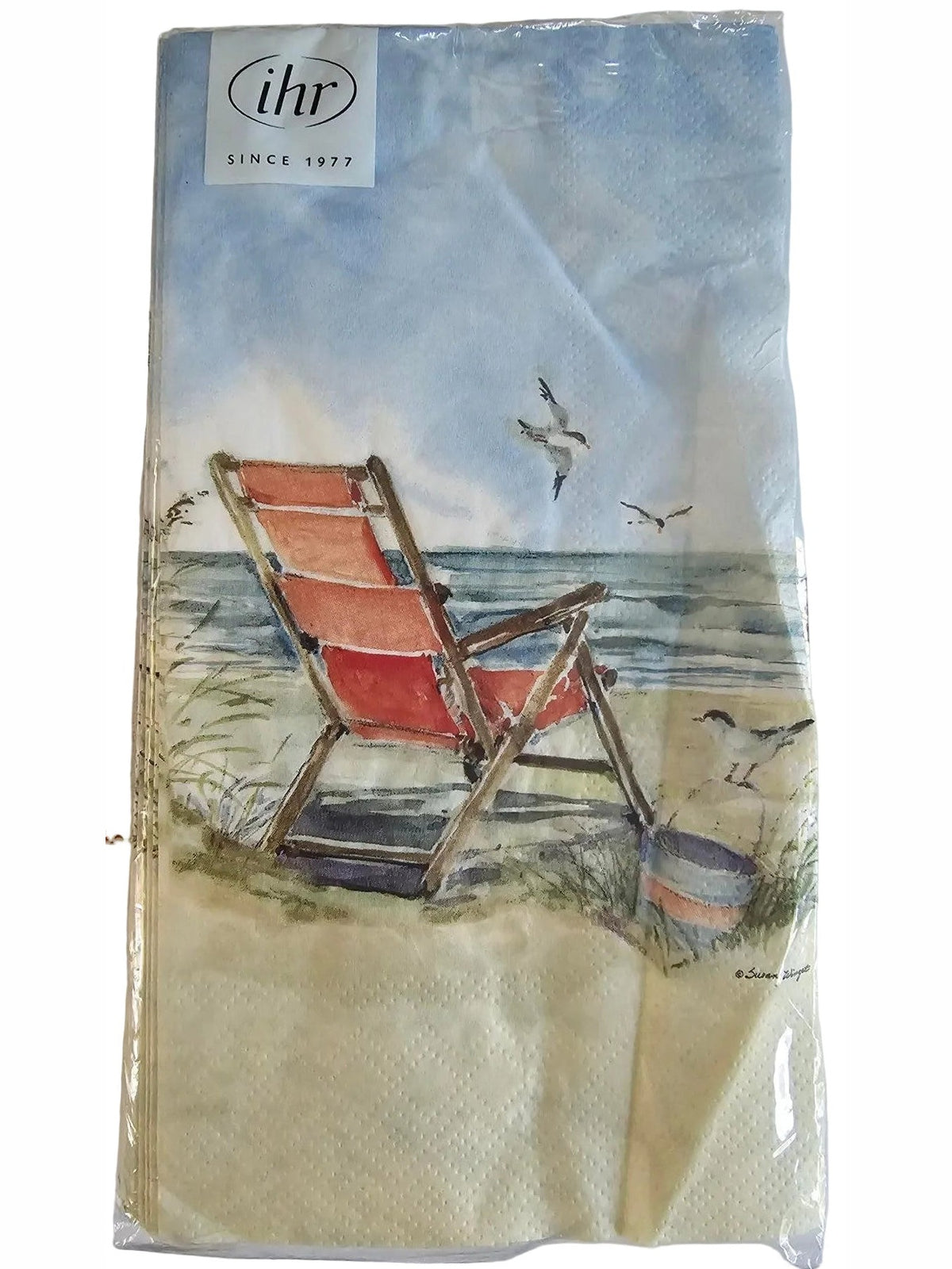 A packaged paper napkin featuring a printed illustration of a red beach chair by a lake with birds and a blue sky, with a visible 'libi' logo on the top right.