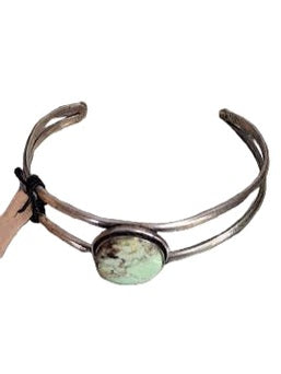 Bracelet with a green stone on a marble surface
