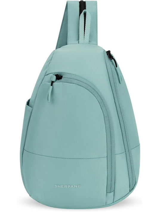 A light mint green sling backpack by Sherpani, featuring a single shoulder strap, a front zippered pocket, and a curved lower body, shown against a plain white background.