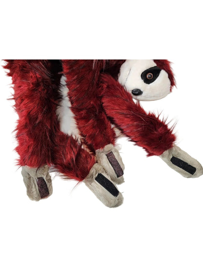 A close-up of a plush toy or costume accessory with a red furry body, gray paw pads, and part of a white face with black eye details, laid on a white surface.