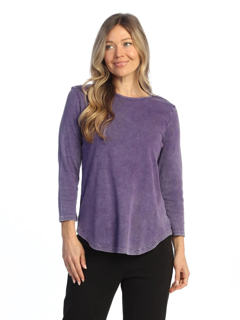 Woman wearing a purple long-sleeve top on a white background
