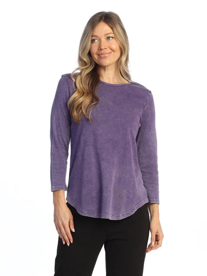 Woman wearing a purple long-sleeve top on a white background