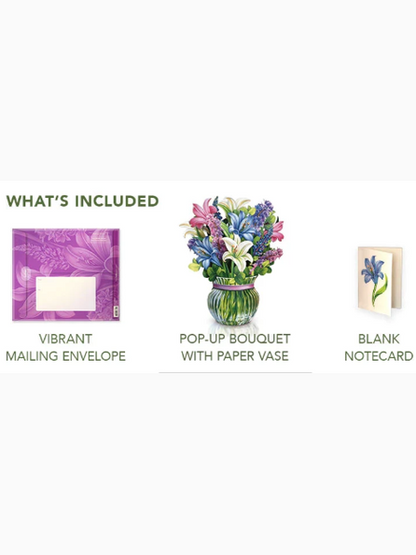 A product inclusion graphic on a white background showing three included items: a purple floral mailing envelope labeled 'Vibrant Mailing Envelope,' a colorful pop-up bouquet with a paper vase labeled 'Pop-Up Bouquet with Paper Vase,' and a blank floral notecard labeled 'Blank Notecard.' Green text at the top reads 'WHAT'S INCLUDED.