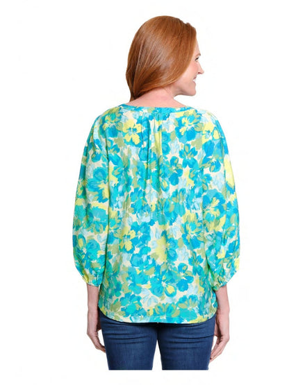 Woman wearing a blue and green floral blouse on a white background