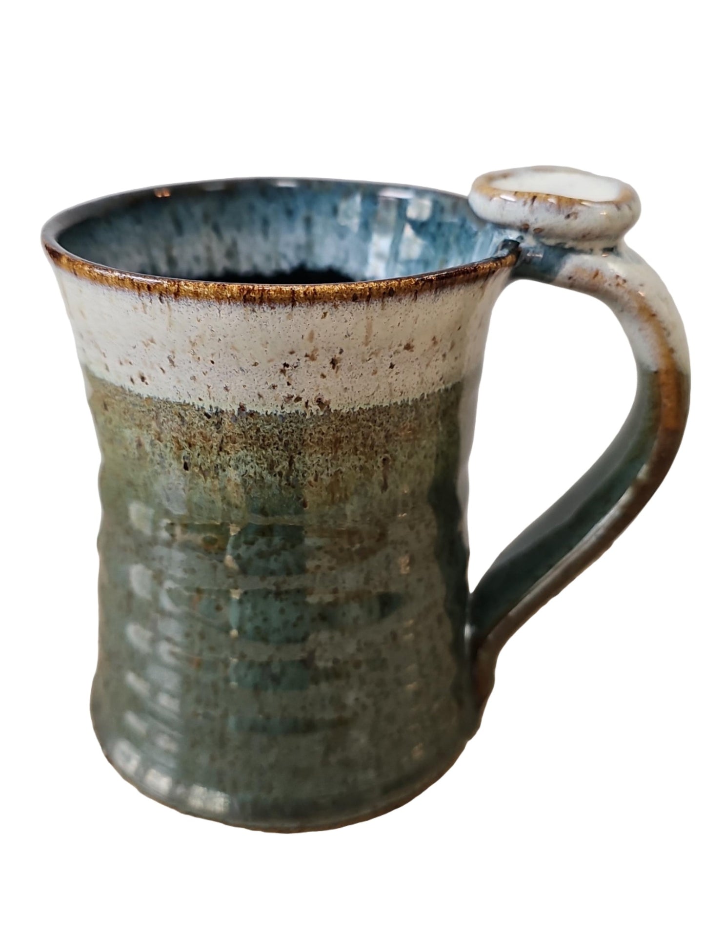 Handmade ceramic mug with a textured surface on a speckled countertop.